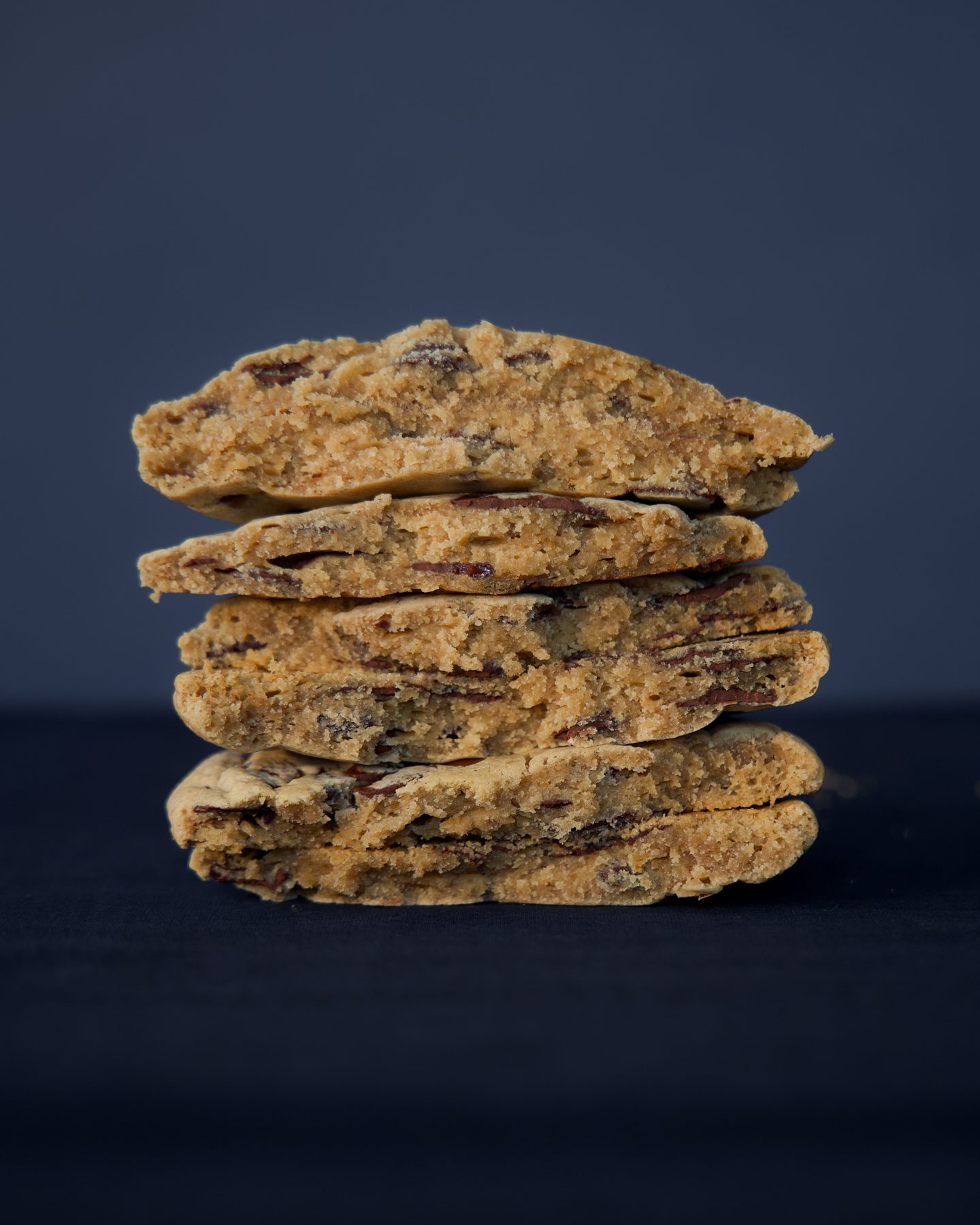 Broken chocolate chip cookies stacked to show their soft centres